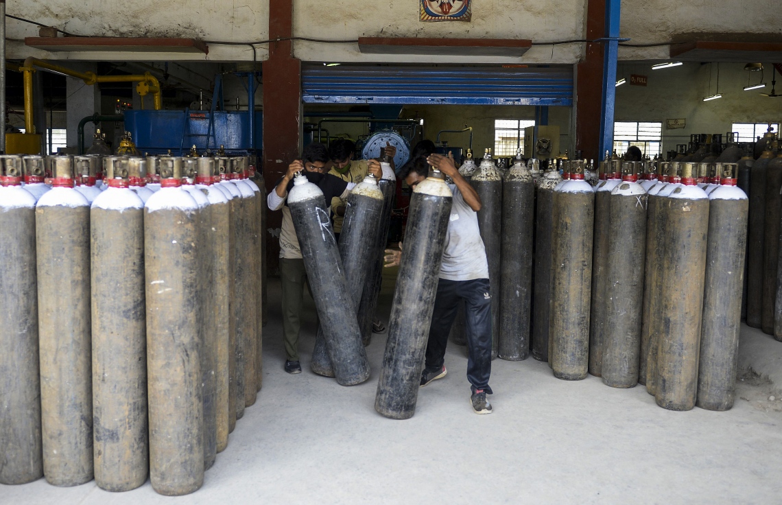 އިންޑީއާ: އޭޕްރިލް 24، 2021: ކޮވިޑް-19 އަށް ފަރުވާދެމުންދާ ބަލިމީހުންނަށް މެޑިކަލް އޮކްސަޖަން ސިލިންޑަރު ފޯރުކޮށްދިމުގައި ފްރަންޓްލައިންގައި މަސައްކަތް ކުރަމުންދާބަޔަކު އެހީތެރިވަނީ.-- ފޮޓޯ: އޭއެފްޕީ