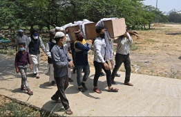 Relatives, friends and graveyard workers carry the body of a Covid-19 coronavirus victim for the burial at a graveyard in New Delhi on April 28, 2021.
Sajjad HUSSAIN / AFP