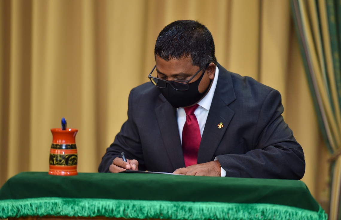 މާލެ: މޭ 6، 2021: ފިޝަރީޒް މިނިސްޓަރަކަށް އައްޔަންކުރެއްވި ޑރ. ހުސެން ރަޝީދު ހަސަން މަގާމުގެ ހުވާކުރެއްވުމަށް ފަހު، އެކަމާ ގުޅޭ ލިޔުންތަކުގައި ސޮއިކުރައްވަނީ.-- ފޮޓޯ: ރައީސް އޮފީސް