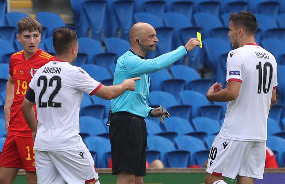 ކާޑިފް، ޖޫން 5، 2021: ޔޫރޯ 2020 އަށް ތައްޔާރުވުމުގެ ގޮތުން ވޭލްސްއާ ދެކޮޅަށް ކުޅުނު މެޗުގައި އަލްބޭނިއާގެ ފޯވާޑް ރޭ މަނާޖް (ރ) އަށް ރީނދޫ ކާޑު ދައްކަނީ. --ފޮޓޯ:އޭއެފްޕީ