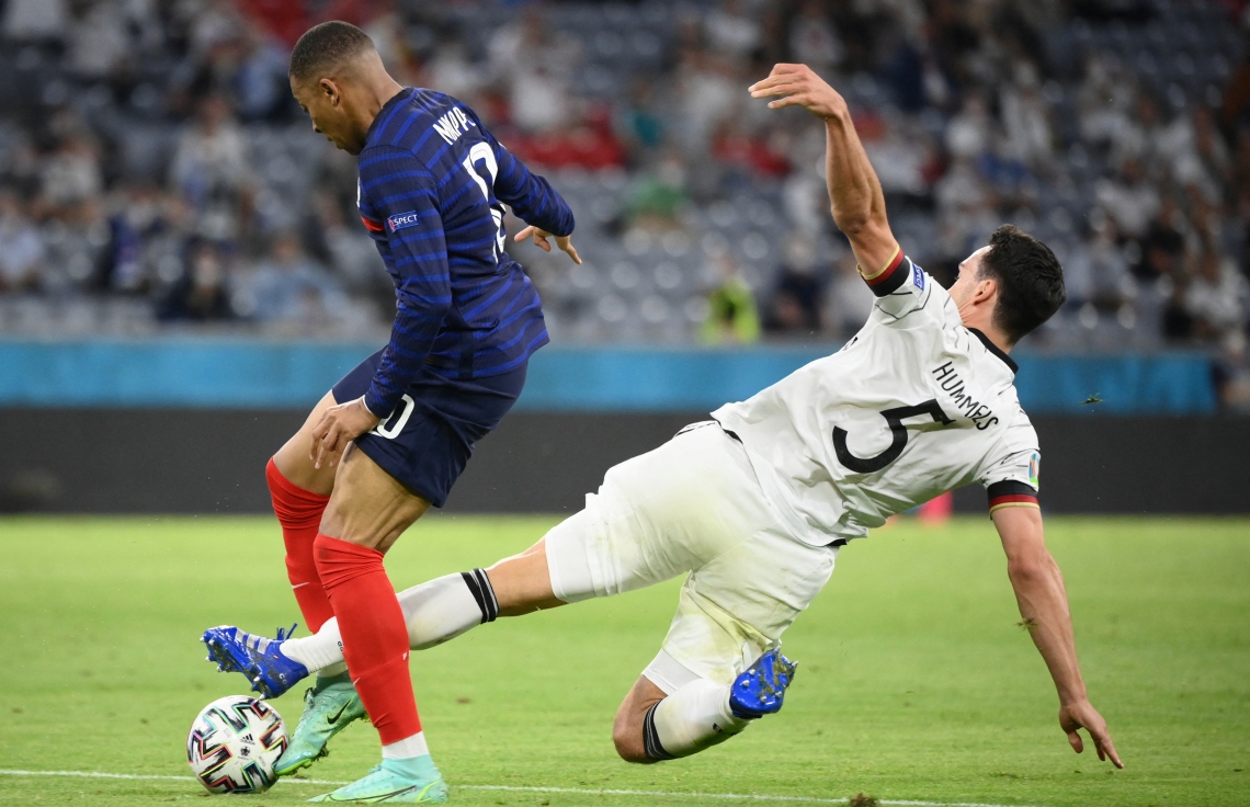 މިއުނިކް: ޖޫން 16، 2021: ޔޫރޯ 2020ގެ ގުރޫޕް އެފްގައި ފްރާންސް އާއި ޖަރުމަން ބައްދަލުކުރި މެޗުގައި ޖަރުމަނުގެ ޑިފެންޑަރު މެޓްސް ހަމެލްސް ފްރާންސްގެ ފޯވާޑް ކިލިއަން އެމްބާޕޭ ބޯޅަ ހޯދުމަށް މަސައްކަތް ކުރަނީ: މި ޗުގައި ޖަރުމަނު އަތުން 0-1 އިން ފްރާންސް ވަނީ ކުރިހޯދާފައި.-- ފޮޓޯ: އޭއެފްޕީ