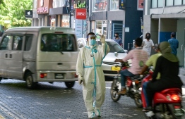 (FILE) Photo taken on June 21 shows health worker in PPE stopping people on the road to take their random sample: HPA has announced all eligible residents of Maldives should get inoculated prior to September 1 -- Photo: Ahmed Awshan Ilyas/ Mihaaru
