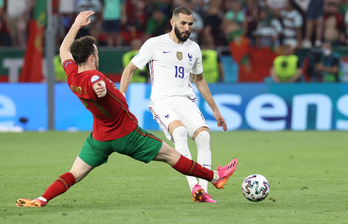 ބުޑަޕެސްޓް: ޖޫން 24، 2021: ޔޫރޯ 2020ގެ ގްރޫޕް އީގެ ފްރާންސް އާއި ޕޯޗުގަލް ބައްދަލުކުރި މެޗުގައި ފްރާންސްގެ ފޯވާޑް ކަރީމް ބެންޒަމާ(ކ) ޕޯޗުގަލްގެ ފޯވާޑް ޑިއާގޯ ޖޯޓާ ޖެހި ބޯޅަ ހޯދުމަށް މަސައްކަތް ކުރަނީ: ފްރާންސްގެ މައްޗަށް 2-2 ގެ ނަތީޖާ އަކުން އެއްވަރުކޮށް ޕޯޗްގަލް ވަނީ ދެވަނަ ބުރަށް ދަތުރު ކޮށްފައި.-- ފޮޓޯ: އޭއެފްޕީ