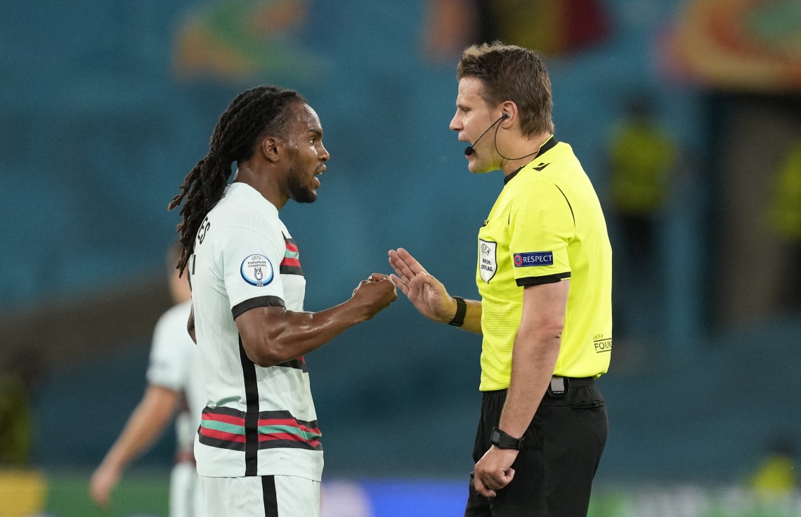 ސެވިއްޔާ - ޖޫން 28، 2021: ޔޫރޯ 2020 ގެ ދެ ވަނަ ބުރުގައި ބެލްޖިއަމާ ދެކޮޅަށް ޕޯޗުގަލް ރޭ ކުޅުނު މެޗުގައި ޕޯޗުގަލްގެ މިޑްފީލްޑަރު ރެނާޓޯ ސަންޗޭޒް (ވ) ރެފްރީ ވާހަކަ ދައްކަނީ: އުމުރުން 23 އަހަރުގެ ސަންޗޭޒް ވަނީ ޕޯޗުގަލްގެ މެދުތެރޭގައި މޮޅު ކުޅުމެއް ދައްކާފައި. --ފޮޓޯ:އޭއެފްޕީ