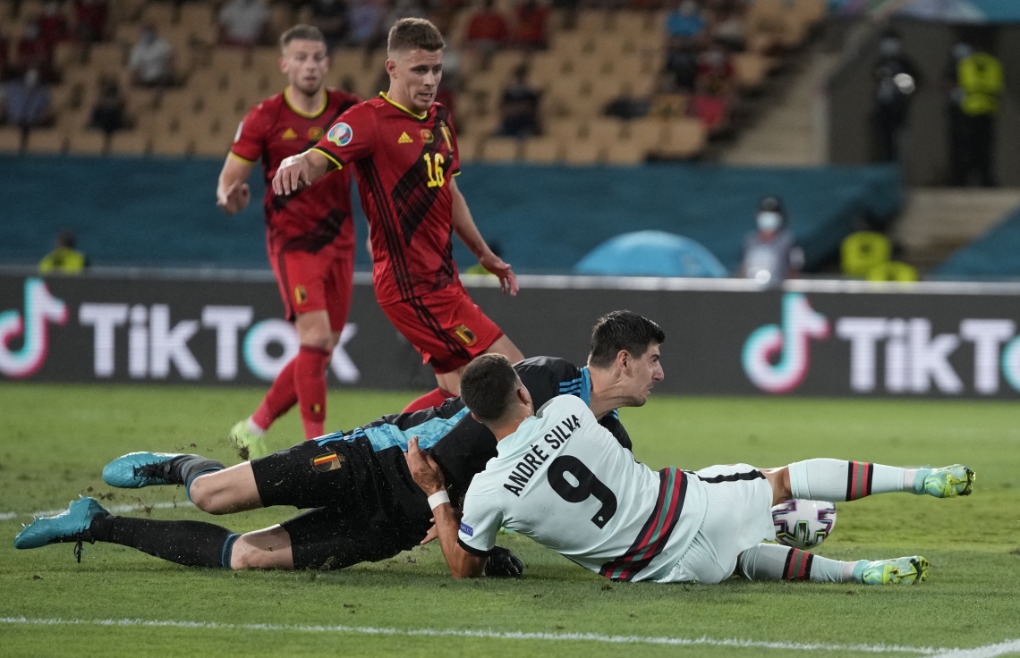 ސެވިއްޔާ - ޖޫން 28، 2021: ޔޫރޯ 2020 ގެ ދެ ވަނަ ބުރުގައި ބެލްޖިއަމާ ދެކޮޅަށް ޕޯޗުގަލް ރޭ ކުޅުނު މެޗުގައި ޕޯޗުގަލްގެ ފޯވާޑް އަންދުރެ ސިލްވާ އަތުން ބޯޅަ އަތުލަން ބެލްޖިއަމްގެ ކީޕަރު ކޯޓުއާ މަސައްކަތް ކުރަނީ: ޕޯޗުގަލް އަތުން 1-0 އިން މޮޅުވެ ބެލްޖިއަމް ވަނީ ކުއާޓަ ފައިނަލަށް ދަތުރުކޮށްފައި. --ފޮޓޯ:އޭއެފްޕީ