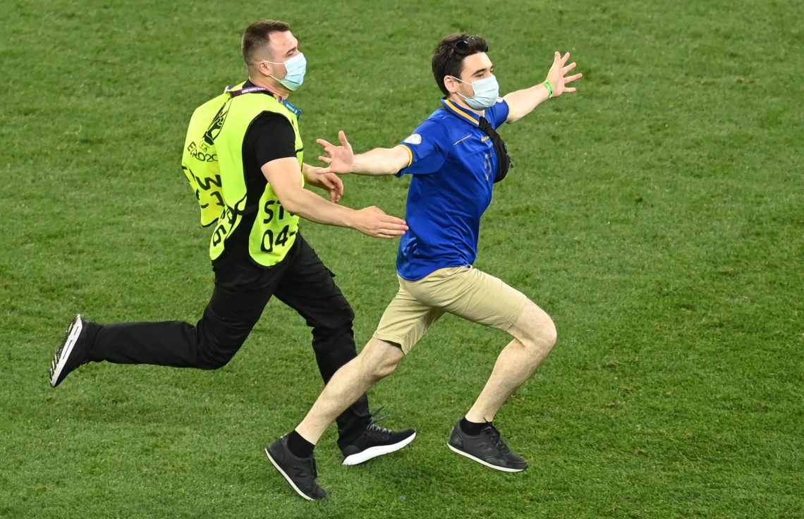 ބުކަރެސްޓް - ޖޫން 28، 2021: ޔޫރޯ 2020 ދެވަނަ ބުރުގައި ފްރާންސް އާއި ސްވިޒަލެންޑް ކުޅުނު މެޗުގައި ދަނޑަށް އެރި ސަޕޯޓަރަކު ސެކިއުރިޓީން ހިފަހައްޓަނީ: މެޗުގެ ފުރިހަމަ ވަގުތާއި އިތުރު ވަގުތު 3-3 އިން އެއްވަރުވުމުން ނަތީޖާ ނެރެން ޖެހި ޕެނަލްޓީ 5-4 އިން ކާމިޔާބު ކުރީ ސްވިޒަލެންޑް. --ފޮޓޯ:އޭއެފްޕީ