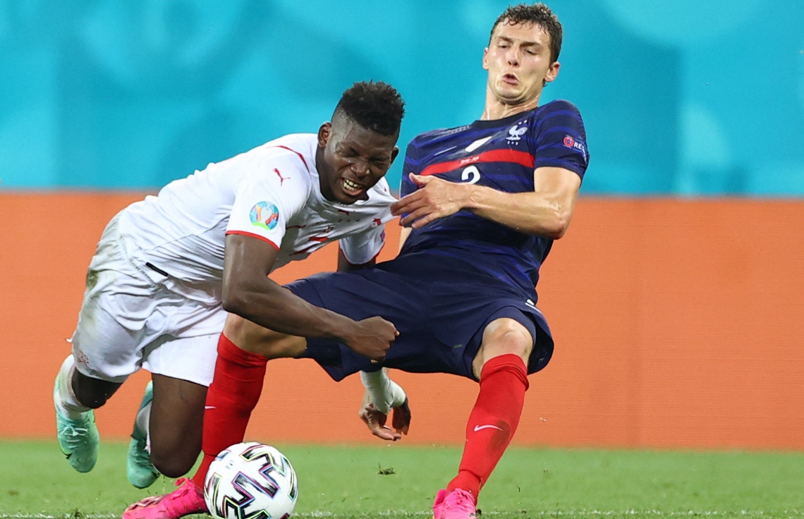 ބުކަރެސްޓް - ޖޫން 28، 2021: ސްވިޒަލެންޑާ ދެކޮޅަށް ކުޅުނު ޔޫރޯ 2020 ދެވަނަ ބުރުގެ މެޗުގައި ފްރާންސްގެ ޑިފެންޑަރު ޕަވާޑް (ކ) އަތުން ބޯޅަ ހޯދަން ސްވިޒަލެންޑުގެ ފޯވާޑް އެމްބޮލޯ މަސައްކަތް ކުރަނީ: މެޗުގެ ފުރިހަމަ ވަގުތާއި އިތުރު ވަގުތު 3-3 އިން އެއްވަރުވުމުން ނަތީޖާ ނެރެން ޖެހި ޕެނަލްޓީގައި 5-4 އިން ބަލިވެ ފްރާންސް ކެޓީ އެމްބާޕޭގެ ޕެނަލްޓީ ނާކާމިޔާބުވުމުން. --ފޮޓޯ:އޭއެފްޕީ