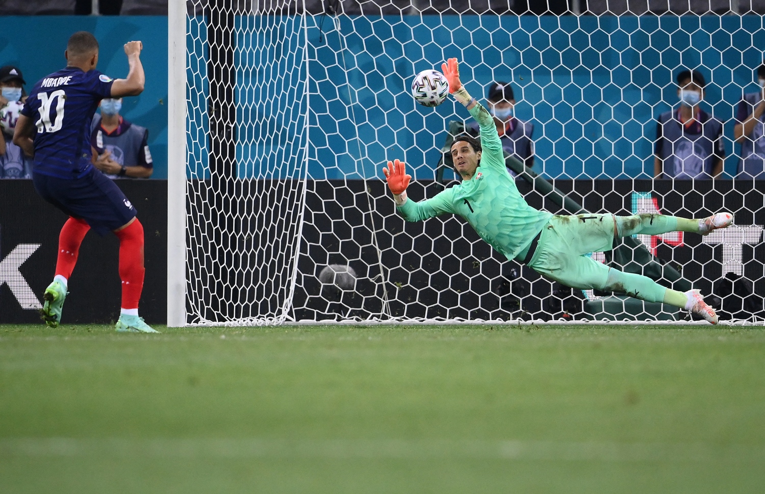 ސްވިޒަލެންޑާ ދެކޮޅަށް ކުޅުނު ޔޫރޯ 2020 ދެވަނަ ބުރުގެ މެޗުގައި ފްރާންސްގެ ފޯވާޑް ކިލިއަން އެމްބާޕޭ ޖެހި ޕެނަލްޓީ ސްވިޒަލެންޑުގެ ކީޕަރު ސޮމާ މަތަކުރަނީ. --ފޮޓޯ:އޭއެފްޕީ