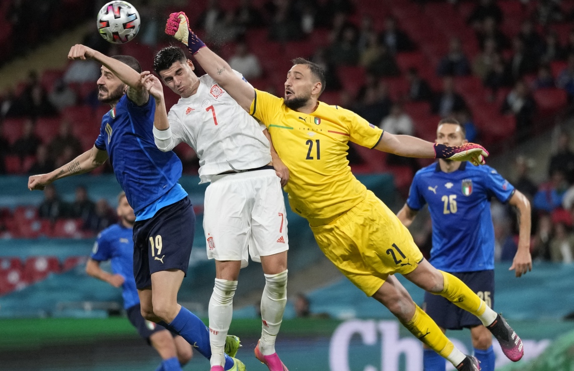 ލަންޑަން - ޖުލައި 6، 2021: ޔޫރޯ 2020 ސެމީ ފައިނަލްގައި އިޓަލީގެ ކީޕަރު ޑޮނަރުއްމާ، އިޓަލީގެ ޑިފެންޑަރު ބަނޫޗީ އަދި ސްޕޭނުގެ ފޯވާޑް މޮރާޓާ ބޯޅަ ހޯދަން މަސައްކަތް ކުރަނީ: މެޗުގެ ފުރިހަމަ ވަގުތާއި އިތުރު ވަގުތުގައި 1-1 އިން ދެ ޓީމު އެއްވަރުވުމުން ނަތީޖާ ނެރެން ޖެހި ޕެނަލްޓީން 4-2 އިން ކުރި ހޯދާ އިޓަލީ ވަނީ ފައިނަލުން ޖާގަ ހޯދާފައި. --ފޮޓޯ:އޭއެފްޕީ