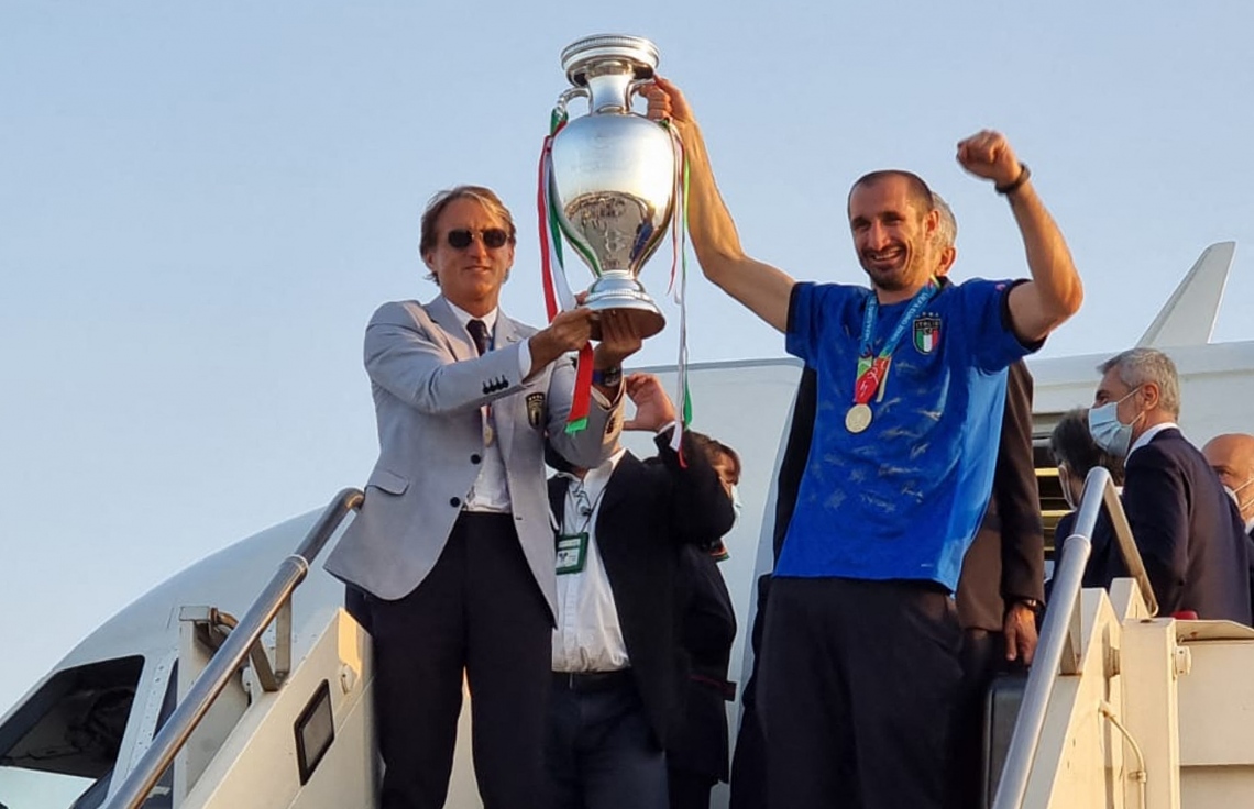 ރޯމް- ޖުލައި 12، 2021: ޔޫރޯ 2020ގެ ފައިނަލްގައި އިންގްލެންޑާ ދެކޮޅަށް ކުޅެ ފުރިހަމަ ވަގުތާއި އިތުރު ވަގުތު 1-1 އިން އެއްވަރުވުމުން ނަތީޖާ ނެރެން ޖެހި ޕެނަލްޓީ 3-2 އިން ކާމިޔާބުކޮށް ޗެމްޕިއަންކަން ހޯދި އިޓަލީ ޓީމުގެ ކޯޗު މަންޗިނީ އާއި ޑިފެންޑަރު ކިއެލިނީ ތައްޓާ އެކު ރޯމް އެއާޕޯޓުގައި. --ފޮޓޯ:އޭއެފްޕީ