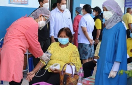 A woman (C) gets her blood pressure checked as officials at Khok Pho Hospital prepare to administer the AstraZeneca vaccine for Covid-19 to some 200 people in the Khok Pho district of Pattani province on July 28, 2021. Photo -- Tuwaedaniya Meringing/AFP