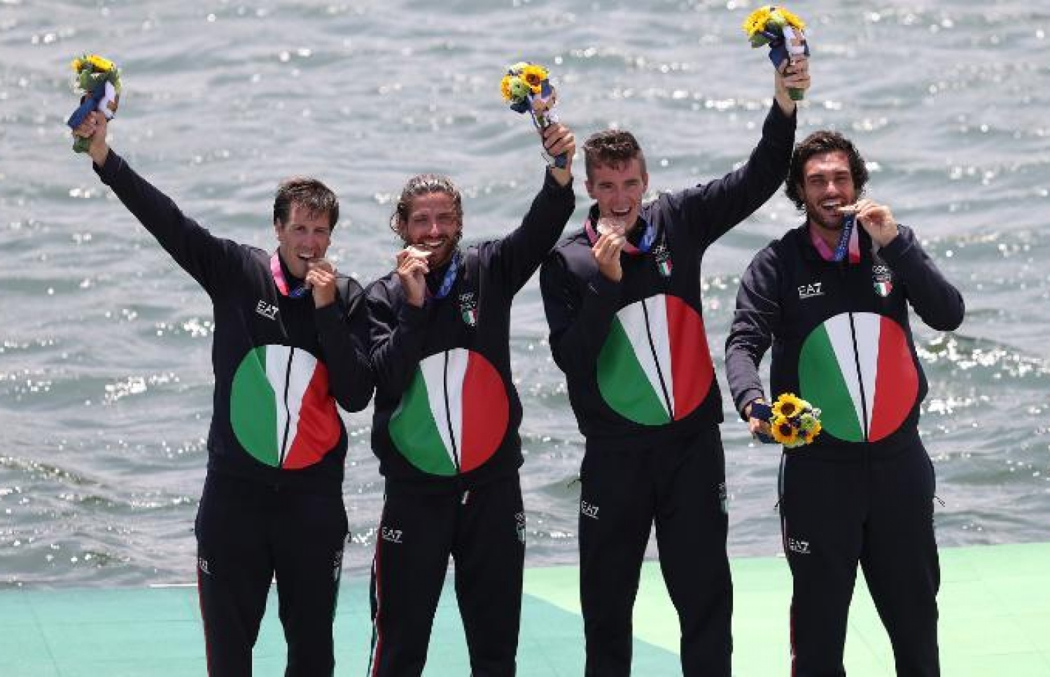 އެތުލީޓުންތަކެއް މެޑެލްއެއްގައި ދަތް އަޅައިގެން ފޮޓޯއަށް އެތުރިގެން.