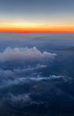 This aerial photograph shows large plumes of smoke rising from forest fires during sunset near Mugla in the Dalaman region of southern Turkey  on August 7, 2021. (Photo by Yasin AKGUL / AFP)