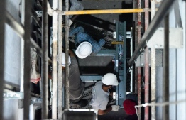 Construction workers installing a lift in Aqua Vita Residences -- Photo: Aqua Vita