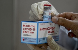A health worker checks a box of the Moderna COVID-19 coronavirus vaccine donated by the US, during a booster vaccination drive at the Zainoel Abidin hospital in Banda Aceh on August 9, 2021 -- Photo Chaideer Mahyuddin/ AFP