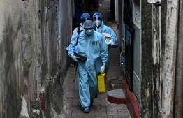 Army health officials walk through an alley during the Covid-19 coronavirus mobile vaccination drive for residents of a locality in Colombo on August 12, 2021. (Photo by Ishara S. KODIKARA / AFP)