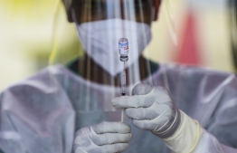 A Police health worker prepares a dose of the Sinopharm vaccine against the Covid-19 coronavirus at a vaccination camp held in Colombo on August 14, 2021. (Photo by ISHARA S.  KODIKARA / AFP)