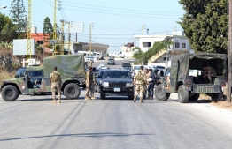 A picture taken on August 15, 2021, shows a Lebanese army soldiers manning a checkpoint near the site of a fuel tank explosion in the village of Tlel in Lebanon's northern region of Akkar. - At least 20 people were killed and nearly 80 others injured when a fuel tank exploded in Lebanon's northern region of Akkar, the Red Cross and state media said. The official National News Agency said the explosion took place following scuffles between "residents that gathered around the container to fill up gasoline" overnight -- Photo by Fathi Al-Masri/ AFP