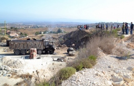 A picture taken on August 15, 2021, shows people gathering at the site of a fuel tank explosion in the village of Tlel in Lebanon's northern region of Akkar. - At least 20 people were killed and nearly 80 others injured when a fuel tank exploded in Lebanon's northern region of Akkar, the Red Cross and state media said. The official National News Agency said the explosion took place following scuffles between "residents that gathered around the container to fill up gasoline" overnigh -- Photo by Fathi Al-Masri/ AFP