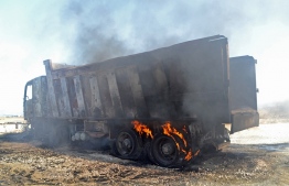 A picture taken on August 15, 2021, shows a burning truck at the site of a fuel tank explosion in the village of Tlel in Lebanon's northern region of Akkar. - At least 20 people were killed and nearly 80 others injured when a fuel tank exploded in Lebanon's northern region of Akkar, the Red Cross and state media said. The official National News Agency said the explosion took place following scuffles between "residents that gathered around the container to fill up gasoline" overnight -- Photo by Fathi Al-Masri/ AFP