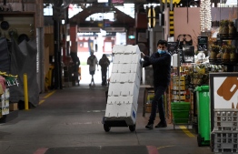 A man wheels boxes through a near-deserted market in Melbourne on August 13, 2021 as the city endures its sixth lockdown -- Photo: William West/ AFP