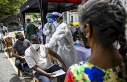 Police health officials inoculate people with a dose of the Sinopharm vaccine against the Covid-19 coronavirus at a vaccination camp held in Colombo on August 14, 2021 -- Photo: Ishara S. Kodikara/ AFP