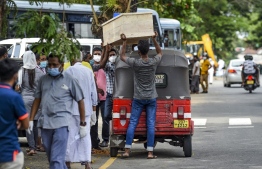 Relatives of a Covid-19 coronavirus victim, prepare to unload a coffin from an auto rickshaw at a mortuary in Colombo on August 16, 2021 -- Photo: Ishara S. Kodikara/ AFP