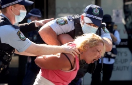 Police officers detain a protestor in Sydney on August 21, 2021, following calls for an anti-lockdown protest rally amid a fast-spreading coronavirus outbreak --Photo: David Gray / AFP
