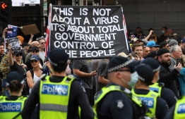 Protesters march through the streets during an anti-lockdown rally in Melbourne on August 21, 2021 as the city experiences it's sixth lockdown while it battle an outbreak of the Delta variant of coronavirus -- Photo by William West/ AFP