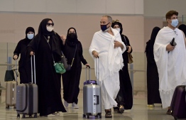 Pilgrims arrive at King Abdulaziz International Airport in the Red Sea coastal city of Jeddah on August 15, 2021, as Saudi Arabia allows vaccinated foreigners to make the off-season Umrah pilgrimage nearly 18 months after it closed its borders to battle coronavirus. (Photo by Amer HILABI / AFP)