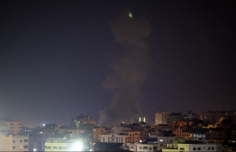 Explosions light-up the night sky above buildings in Gaza City as Israeli forces shell the Palestinian enclave, early on August 22, 2021. - Israel struck Gaza on Saturday after clashes between its troops and Palestinians protesters on the border left dozens injured, including an Israeli policeman and a 13-year-old Palestinian boy who were both critically wounded -- Photo: Mahmud Hams/ AFP