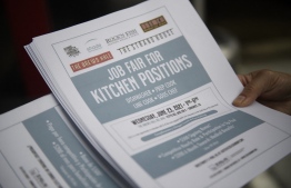 (FILES) In this file photo taken on June 23, 2021 An employer holds flyers for hospitality employment during a Zislis Group job fair at The Brew Hall in Torrance, California: part of the US population that left the workforce in 2020 never returned, leading to a gap in the workforce -- Photo by Patrick T. Fallon / AFP