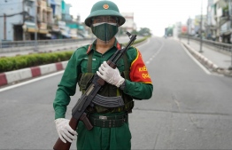 (FILES) In this file photo taken on August 23, 2021, a Vietnamese military personnel stands guard on a deserted road in Ho Chi Minh City, after the government imposed a stricter lockdown to stop the spread of the Covid-19 coronavirus. -- Photo: Pham Tho/ AFP