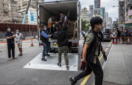 Police officers (C) from the National Security Department take away items after raiding the June 4 museum dedicated to the 1989 Tiananmen Square crackdown, in Hong Kong on September 9, 2021.  -- Photo: Isaac Lawrence/ AFP