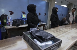 Afghan women airport workers are pictured at a security checkpoint of the airport in Kabul on September 12, 2021. - Of the more than 80 women working at the airport before Kabul fell to the Taliban on August 15, just 12 have returned to their jobs. -- Photo: Karim Sahib/ AFP