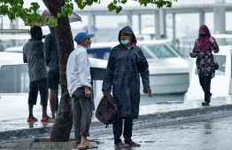 A few locals by the jetty-side on a rainy day -- Photo: Ahmed Avshan/Mihaaru