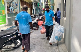 Male City Council's waste management department staff at work.