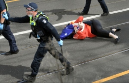 A protester is pushed to the ground by the police during an anti-lockdown rally in Melbourne on September 18, 2021. -- Photo: William West/ AFP