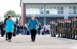 (L-R) Brigadier General Jens Arlt, German Defence Minister Annegret Kramp-Karrenbauer and German Chancellor Angela Merkel attend a military roll call of the military evacuation operation (MilEvakOp), in Seedorf, northern Germany on September 22, 2021. -- Photo: Hauke-Christian Dittrich/ AFP