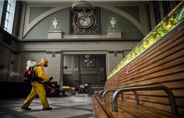 A serviceman of Russia's Emergencies Ministry, wearing protective gear, disinfects Kievsky railway terminal amid the COVID-19 pandemic in Moscow on September 22, 2021. -- Photo: Alexander Nemenov/ AFP