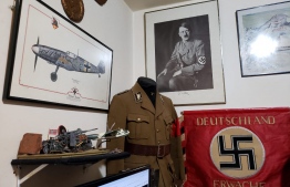 Handout picture released on October 6, 2021 by Rio de Janeiro Civil Police showing Nazi  uniforms, pictures, flags and documents found inside the house of a man suspected of raping a 12-year-old boy at the Vargem Grande neighbourhood, Rio de Janeiro, Brazil. -- Photo: Rio De Janeiro Civil Police/ AFP