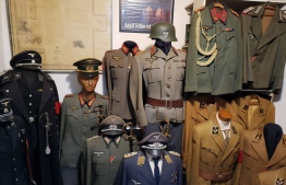 Handout picture released on October 6, 2021 by Rio de Janeiro Civil Police showing Nazi  uniforms found inside the house of a man suspected of raping a 12-year-old boy at the Vargem Grande neighbourhood, Rio de Janeiro, Brazil. -- Photo: Rio De Janeiro Civil Police/ AFP