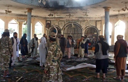 Taliban fighters investigate inside a Shiite mosque after a suicide bomb attack in Kunduz on October 8, 2021. — Photo: AFP