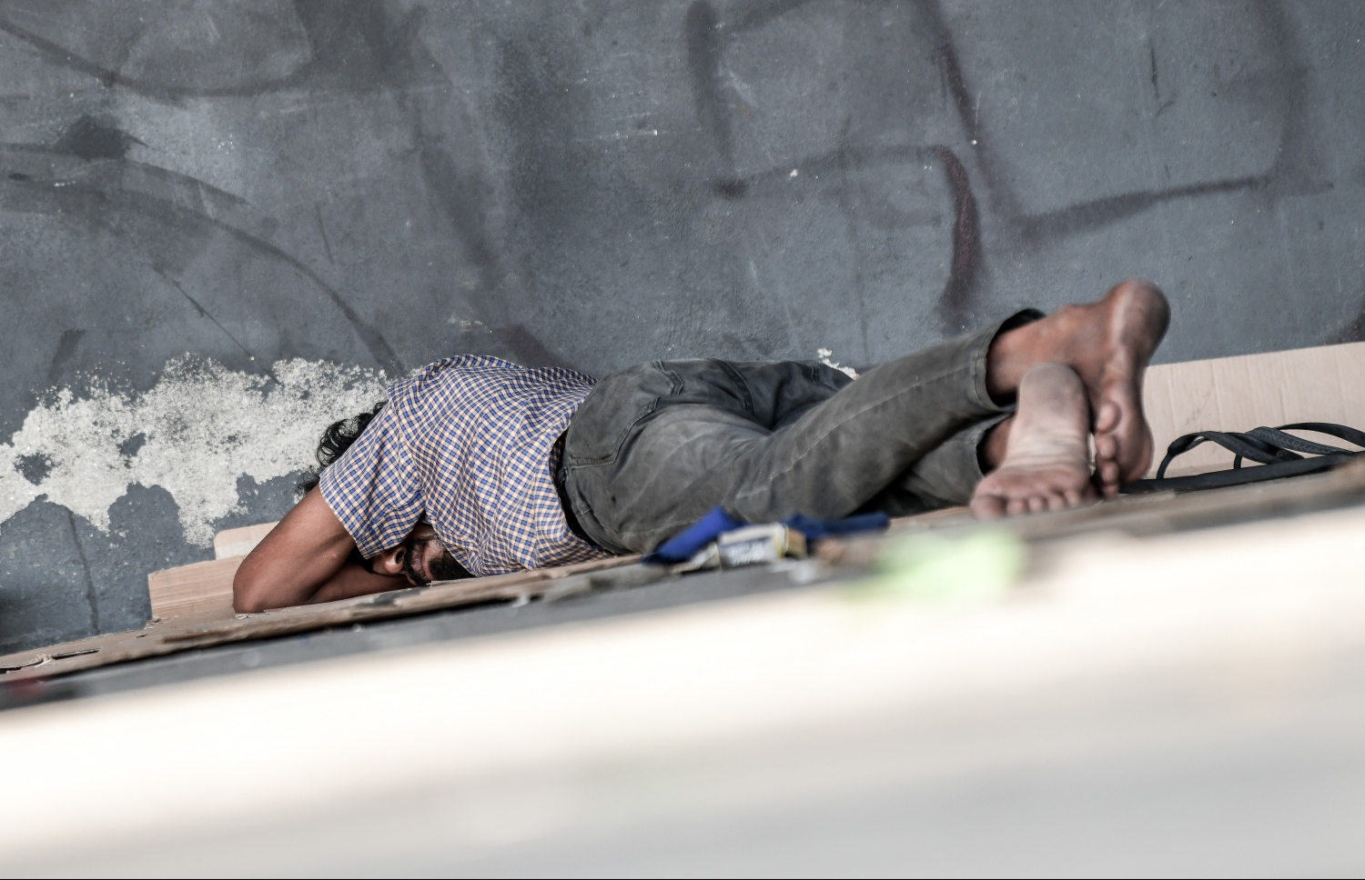 ކާނިވާ ސްޓޭޖުގައި މީހަކު ނިދާފައި އޮތް މީހެއް. މިމީހުން ނިދަން ބޭނުން ކުރަނީ ޕާކުތަކާއި އަނދިރި ފަޅު ތަންތަން.-- ފޮޓޯ: ނިޝާން އަލީ/މިހާރު