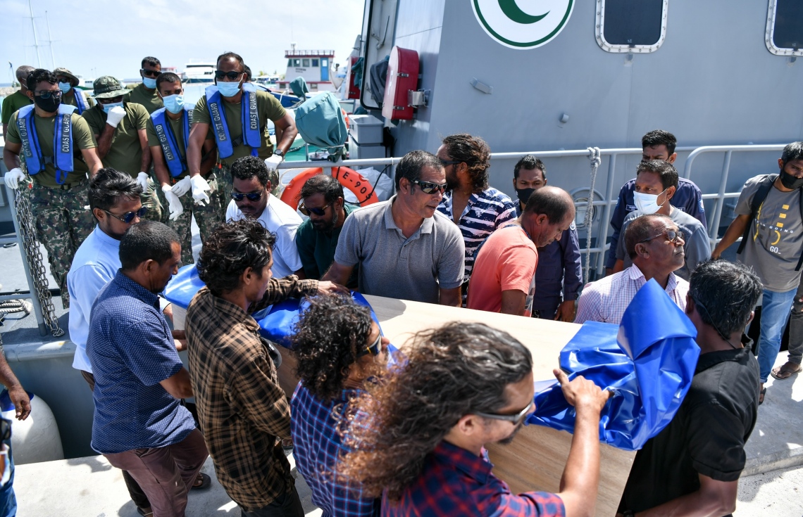 ދަނގެތި: އޮކްޓޯބަރު 15، 2021- މި ރަށުގައި އިހާނެތިކޮށް މަރާލައި އެއްލާލާފައި އޮއްވައި ފެނުނު ވިޔަފާރިވެރިޔާ މަހުމޫދު އަބޫބަކުރުގެ ހަށިގަނޑުގެ ޓެސްޓްތަކެއް ހެދުމަށް ފަހު ކޯސްޓްގާޑްގައި މިއަދު އަބުރާ ދަނގެއްޗަށް ގެންނަނީ.-- ފޮޓޯ: ނިޝާން އަލީ/ މިހާރު