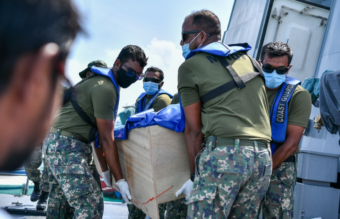 ދަނގެތި: އޮކްޓޯބަރު 15، 2021- މި ރަށުގައި އިހާނެތިކޮށް މަރާލައި އެއްލާލާފައި އޮއްވައި ފެނުނު ވިޔަފާރިވެރިޔާ މަހުމޫދު އަބޫބަކުރުގެ ހަށިގަނޑުގެ ޓެސްޓްތަކެއް ހެދުމަށް ފަހު ކޯސްޓްގާޑްގައި މިއަދު އަބުރާ ދަނގެއްޗަށް ގެންނަނީ.-- ފޮޓޯ: ނިޝާން އަލީ/ މިހާރު