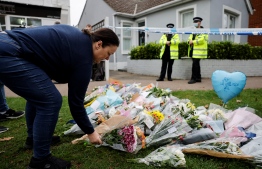 A well-wisher lays a floral tribute at the scene of the fatal stabbing of Conservative British lawmaker David Amess, at Belfairs Methodist Church in Leigh-on-Sea, a district of Southend-on-Sea, in southeast England on October 16, 2021 -- Photo: Tolga Akmen / AFP