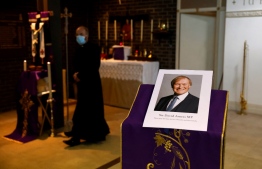A photograph of Conservative British lawmaker David Amess, who was fatally stabbed, is pictured prior to a service at Saint Peter's Catholic Parish of Eastwood in Leigh-on-Sea in southeast England on October 15, 2021. -- Photo: Tolga Akmen / AFP