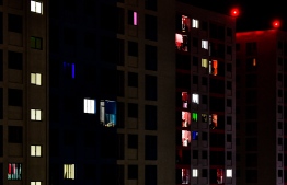 Two individuals put Christian literature into a mailbox in a Hiya flat tower. -- Photo: Mihaaru