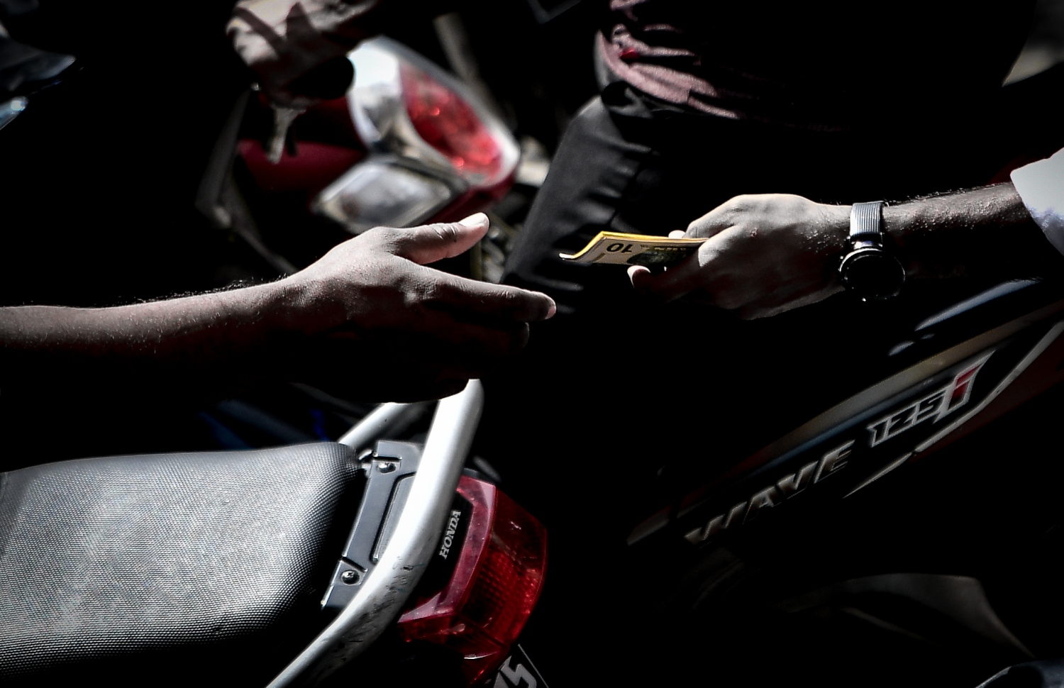 ބީއެމްއެލް ޑޮލަރު އޭޓީއެމް ކައިރީގައި ބަޔަކު ފައިސާ މާރު ކުރަނީ: ގަވައިދާ ހިލާފު ރޭޓުތަކުގައި މިކަން ކުރަނީ ވަރަށް ފުޅާކޮށް. އެކަމަކު މިކަން ހުއްޓުވަން ކަމާ ބެހޭ ފަރާތްތަކުން ވަނީ ނުކުޅެދިފައި -- ފޮޓޯ: ނިޝާން އަލީ/މިހާރު